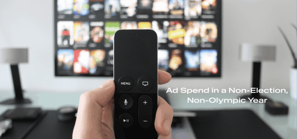 Image of remote control with a TV in the background showing different movies; Ad spend