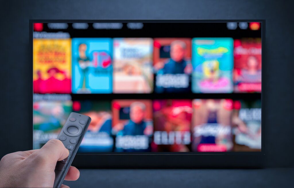 remote pointing at a TV with blurred out shows